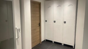 A hallway with a wooden door and three white lockers with the word "Ski" on them. - Luxury residence in Métabief, suites, apartments, private spa and sauna (METABIEF)