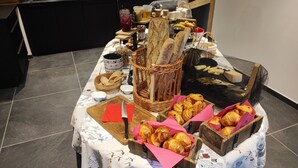 A table with bread, pastries, and a basket of baguettes. - Luxury residence in Métabief, suites, apartments, private spa and sauna (METABIEF)