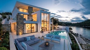 A modern two-story house with a swimming pool, outdoor seating, and a view of a river. - Villa Vigora - Private villa with pool in Korcula (Uvala Vrbovica)