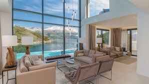 A spacious living area with a large window overlooking a lake and mountains. - Villa Vigora - Private villa with pool in Korcula (Uvala Vrbovica)