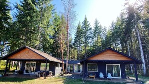 Two cabins with large windows, surrounded by a forest. - Forest Hideaway House with hot tub and trail (Shelton)