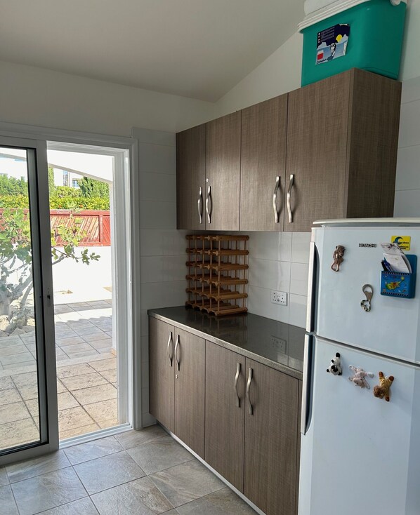 Una cocina con armarios de madera, un refrigerador blanco y un botellero.