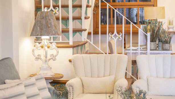 A living room with a staircase, a lamp, and a sofa. - El traslado Alojamiento (Almonte)