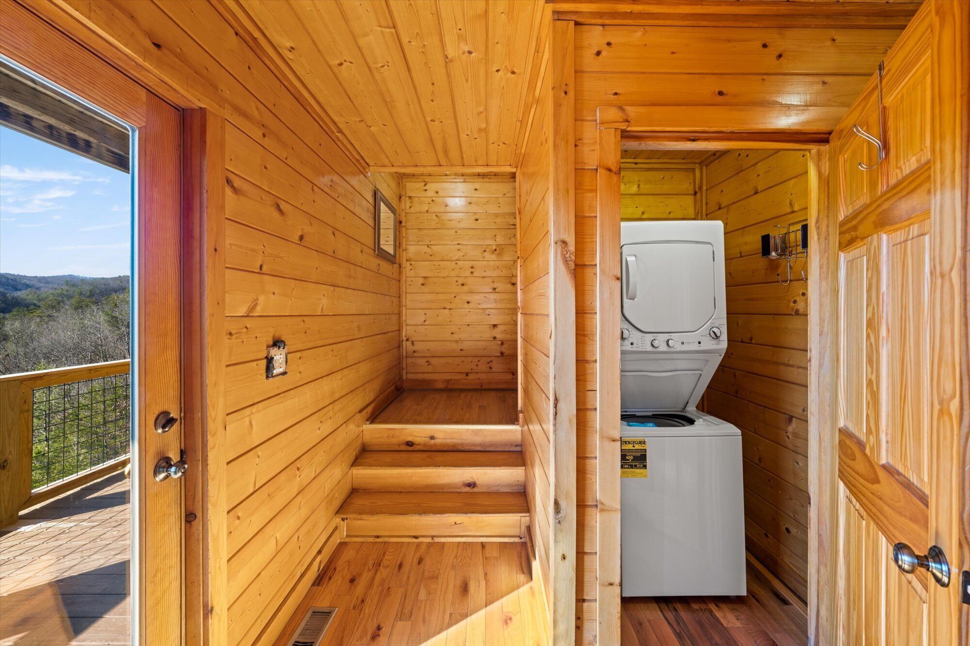 Una cabaña de madera con lavandería, que incluye una lavadora y un tendedero de metal.