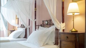 Un dormitorio con dos camas, una mesita de noche, una lámpara y un armario de madera.