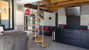 A modern kitchen with dark cabinets, a stainless steel range hood, and a red toaster.