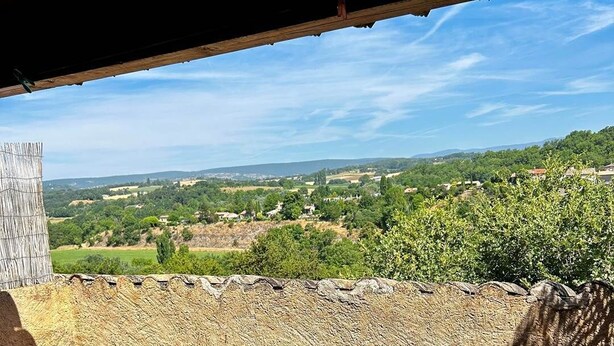 A terrace with a table and chairs, overlooking a rural landscape with fields and houses. - Gîte 2 Personnes Bruyère - 35 m² (Niozelles)