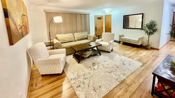 A living room with a sofa, armchairs, a coffee table, and a rug. - Comfortable 3BR Home-Prime Video, WiFi, Parking (Schererville)