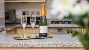 A bottle of Crémant de Loire wine on a tray with two glasses on a kitchen counter. - Unique Property in the Heart of Winchester (Winchester)