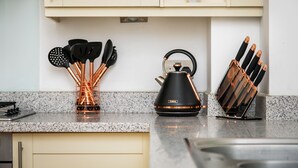A kitchen with a granite countertop, a kettle, and a knife block. - Unique Property in the Heart of Winchester (Winchester)