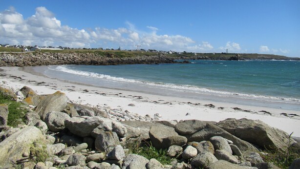 A coastal beach with rocky foreground, calm sea, and houses in the background. - DETACHED HOUSE 100 M2 ON A 936 M2 ENCLOSED PLOT AT THE END OF A CUL-DE-SAC (Porspoder)