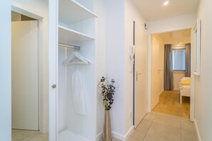 A hallway with a white wardrobe, a hanging garment, and a vase with flowers. - Im Haus Befinden Sich Diese Moderne und Gemütlich Eingerichtete Ferienwohnungen für 1 bis 2 Personen. Das App. Kompass Befindet Sich im Zweiten Stockwerk des Hauses Friedrichstraße 40, zu Erreichen Über den Fahrstuhl. Das Appartement ist neu r (Westerland)