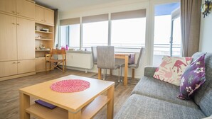 Ein gemütliches Wohnzimmer mit einer Couch, einem Couchtisch und einem Essbereich mit Stühlen und einem Tisch.