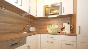 A compact kitchen with a built-in microwave, a coffee maker, and a toaster. - House Sylter Welle 8-87, OB (Sylt/Westerland)