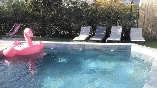 Una piscina amb un flamac màgic rosa i gandules.
