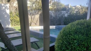 Zona de piscina amb vista despejada, gespa ben cuidada i arbust tallat amb cura.
