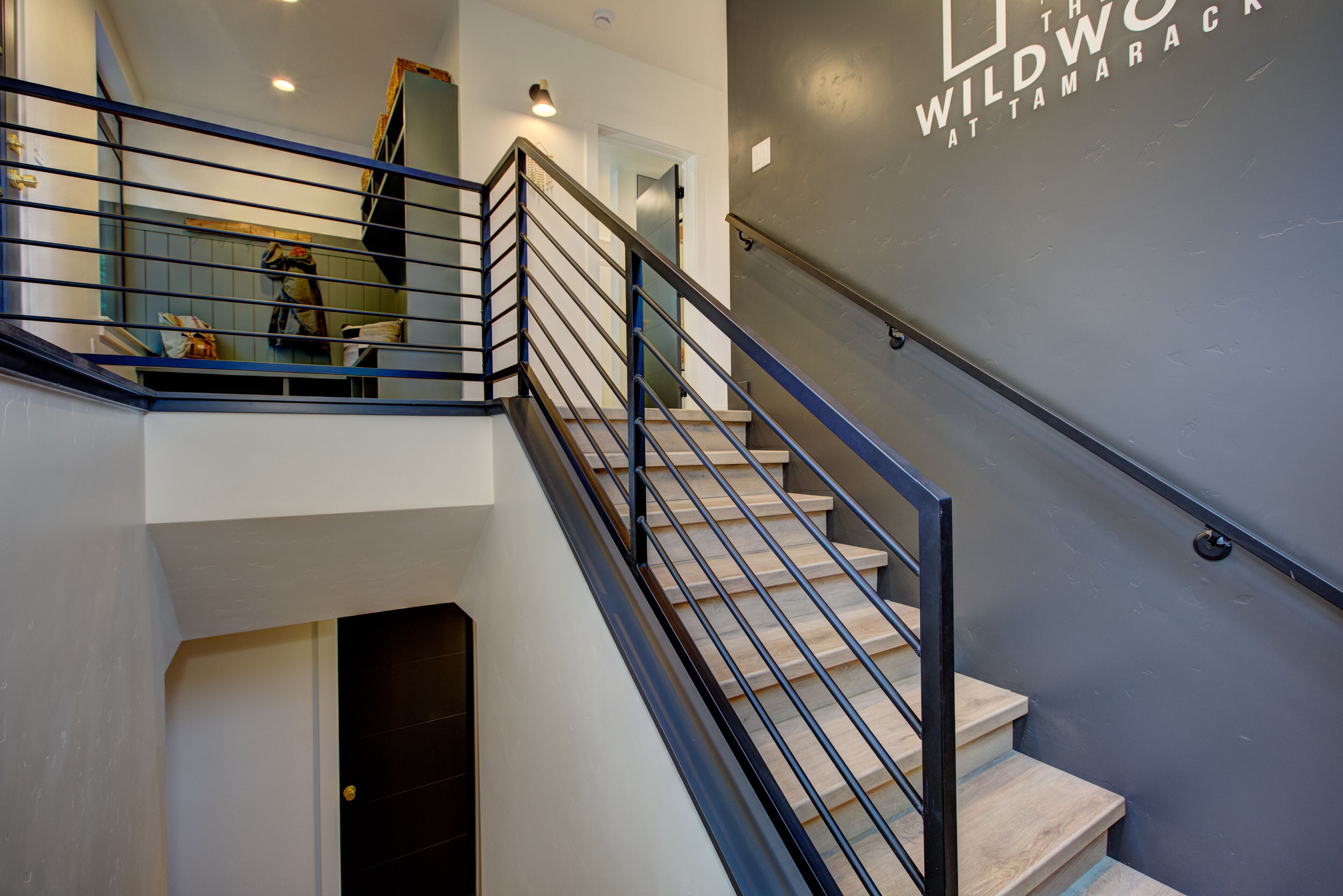 A staircase with metal railings and a wall with a logo.