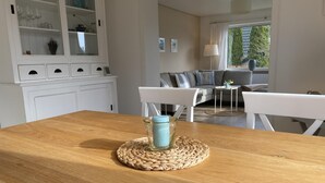 Una mesa de madera con un posavasos tejido y un candelabro azul.
