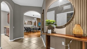 Ein modernes Interieur mit Essbereich, Küche und einem großen Spiegel.