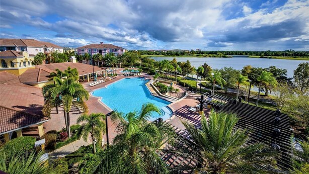 Ein Resort mit großem Pool, Palmen und Seeblick.