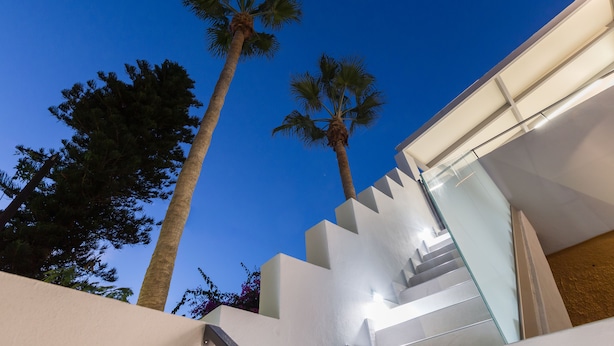 A modern building with a glass staircase and palm trees. - Antigoni's Seaside Lodge (Rethymno)