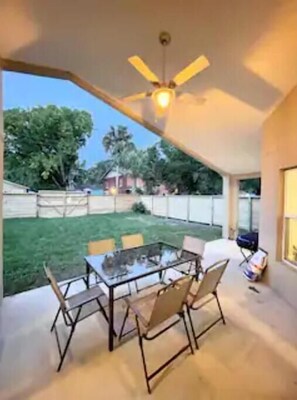 Relax on the patio surrounded by lush greenery and enjoy the view from the comfort of your outdoor seating area.