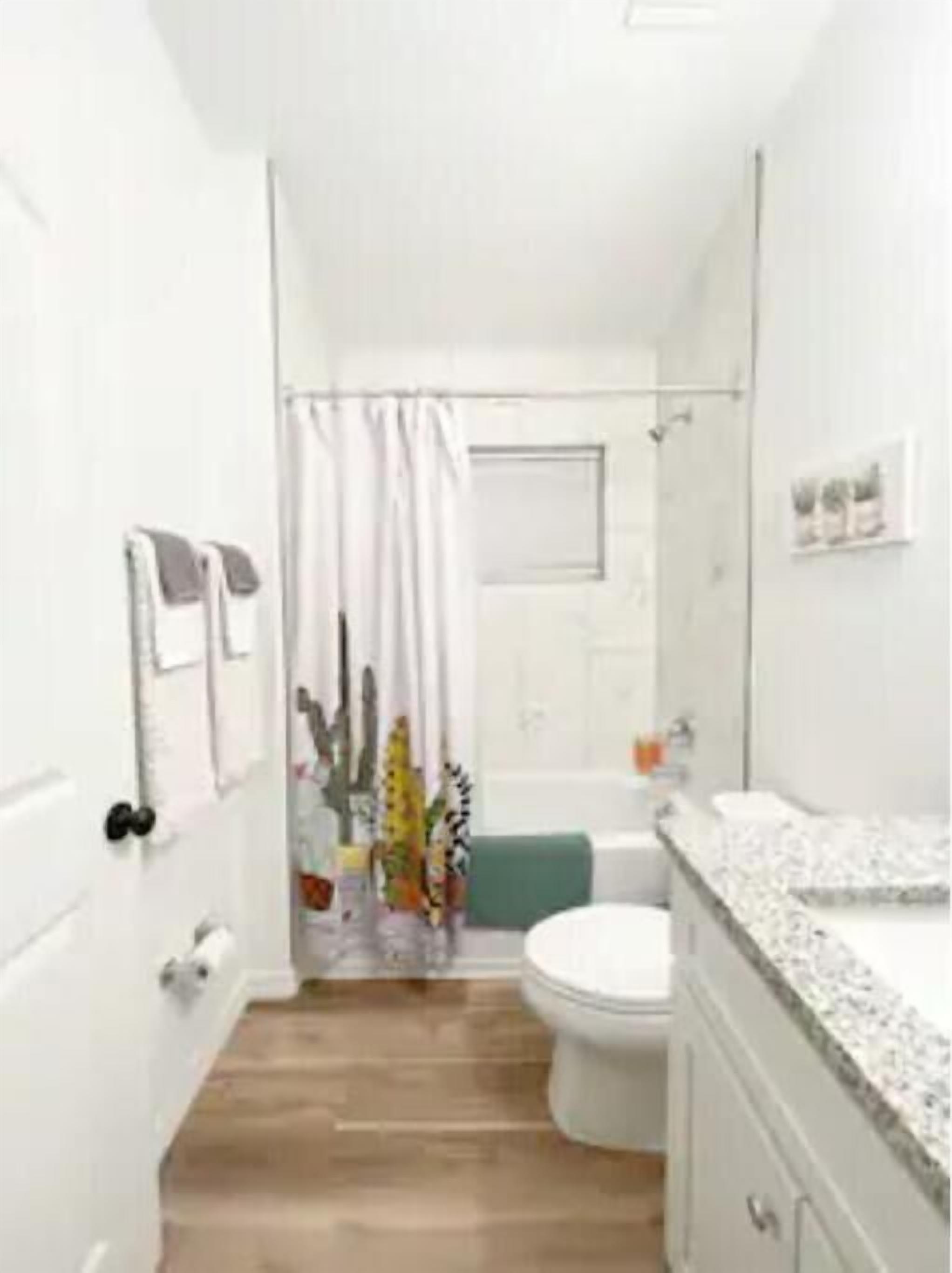 A bathroom with a toilet, sink, and shower area.