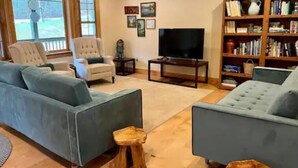 A living room with two sofas, a television, and a bookshelf.