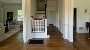 A spacious hallway with wooden flooring, a white staircase with a wooden railing, and a chandelier. - Welcome to Summerville! 1.0 miles from the Augusta National (Augusta)