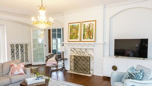 A living room with a fireplace, a television, and two framed artworks on the wall. - Welcome to Summerville! 1.0 miles from the Augusta National (Augusta)