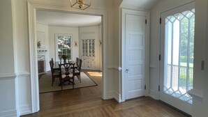 A spacious room with hardwood flooring, a dining area with a table and chairs, and a large window with a view of greenery. - Welcome to Summerville! 1.0 miles from the Augusta National (Augusta)