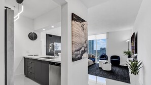 A modern apartment with a kitchen, living area, and large windows offering a city view.