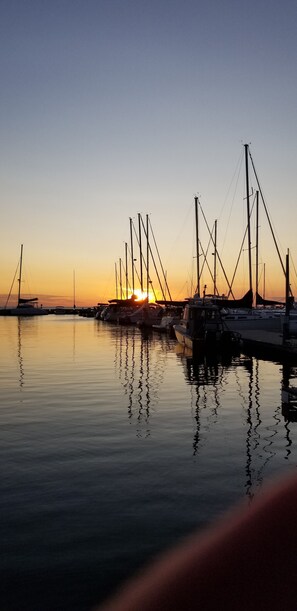 A marina with multiple sailboats docked at sunset.