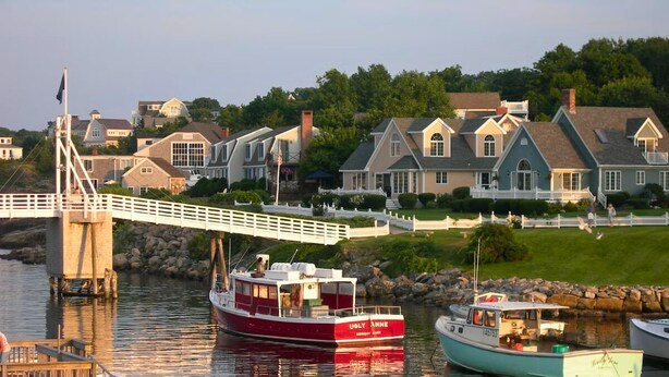 A river with boats docked at a pier, a white bridge, and houses in the background. - Historical charm | Modern amenities | Unbeatable location (Ogunquit)