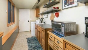 A compact kitchen with wooden cabinets, a built-in microwave, and a small countertop.