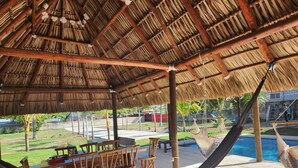 A covered outdoor area with wooden furniture and a hammock. - VILLA CLAUDIAS (Taxisco)
