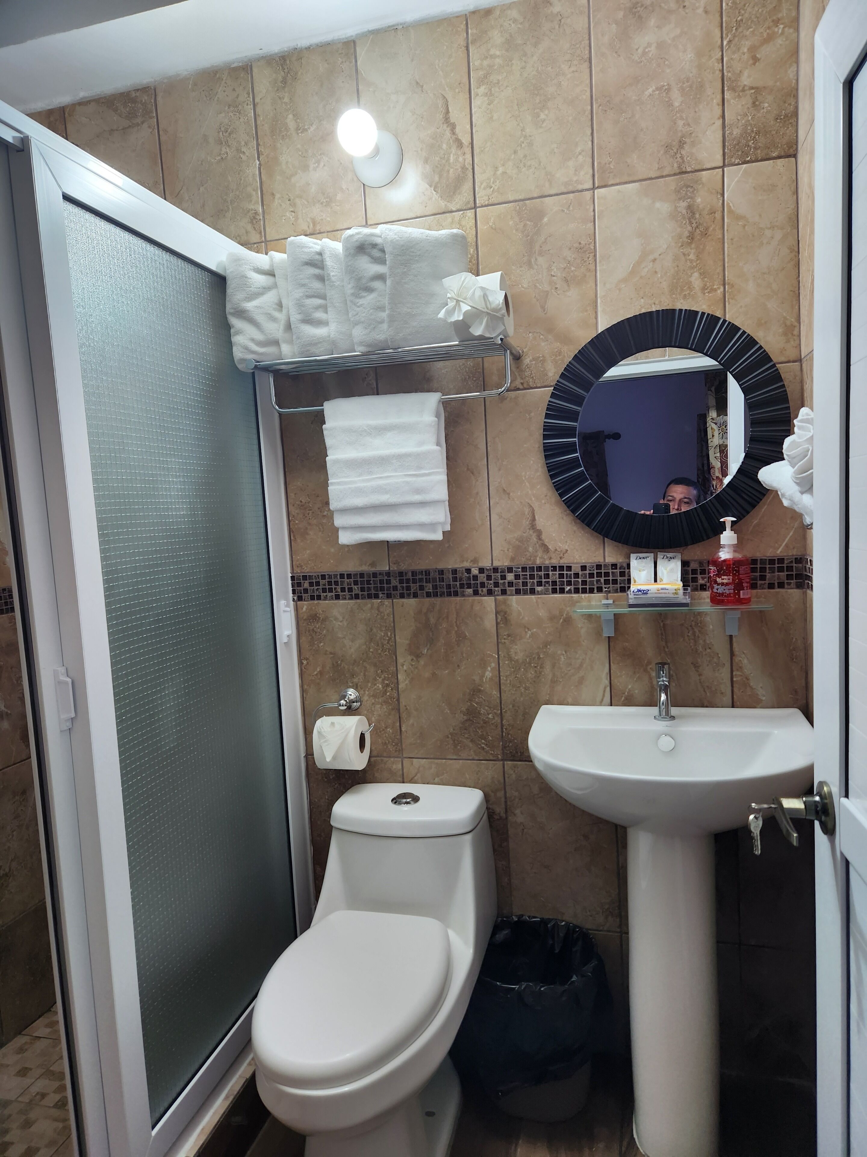 Ein Badezimmer mit Toilette, Waschbecken und einer Duschkabine aus Glas.
