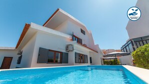 A modern two-story building with a swimming pool in front. - Portimão: villa with heatable pool & BBQ (Portimão)