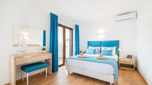 A bedroom with a bed, a desk, a chair, a bedside table, and a window with curtains. - Portimão: villa with heatable pool & BBQ (Portimão)