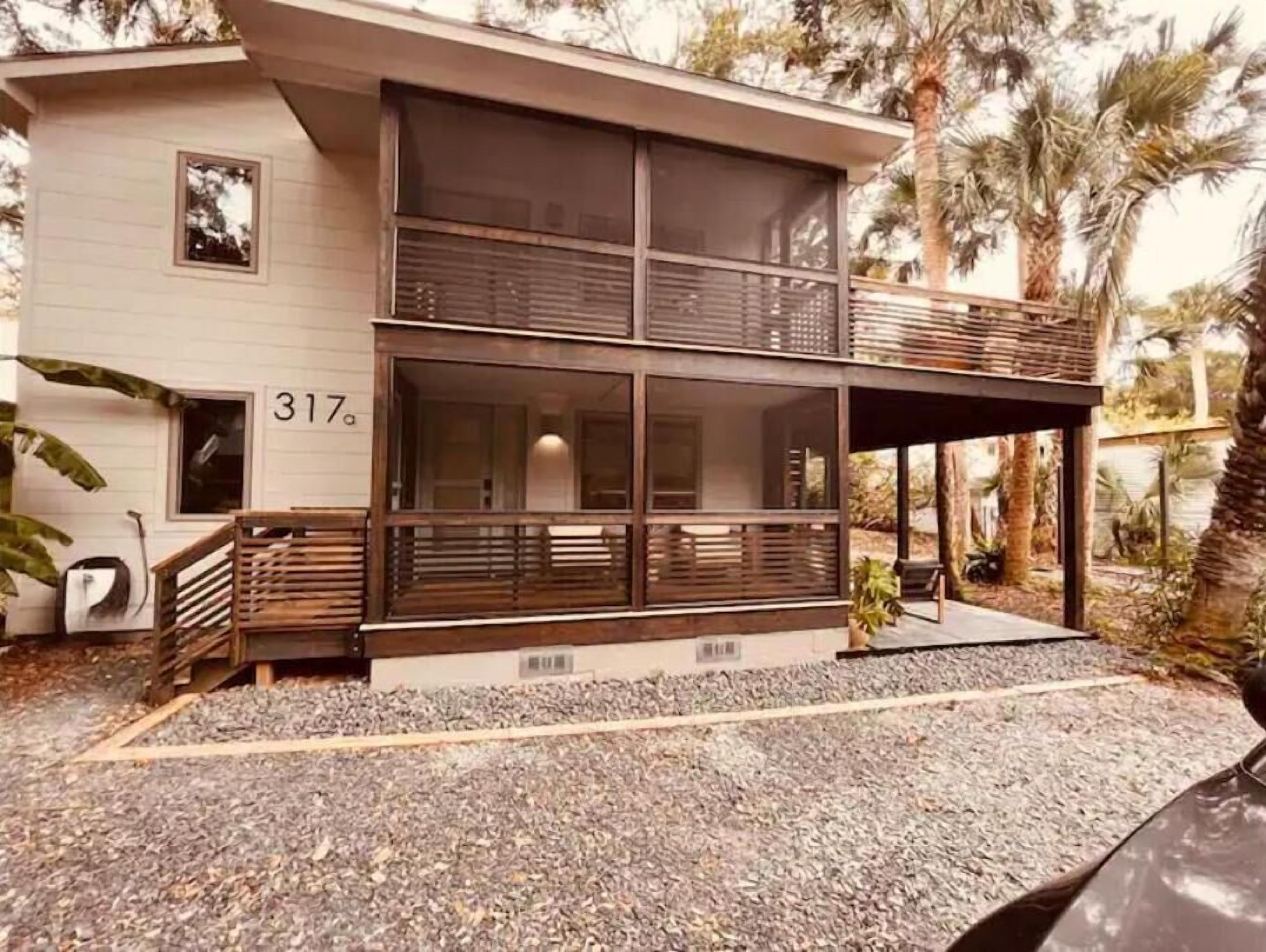 Een modern huis met twee verdiepingen, een balkon, grote ramen en het nummer '317' aan de zijkant.