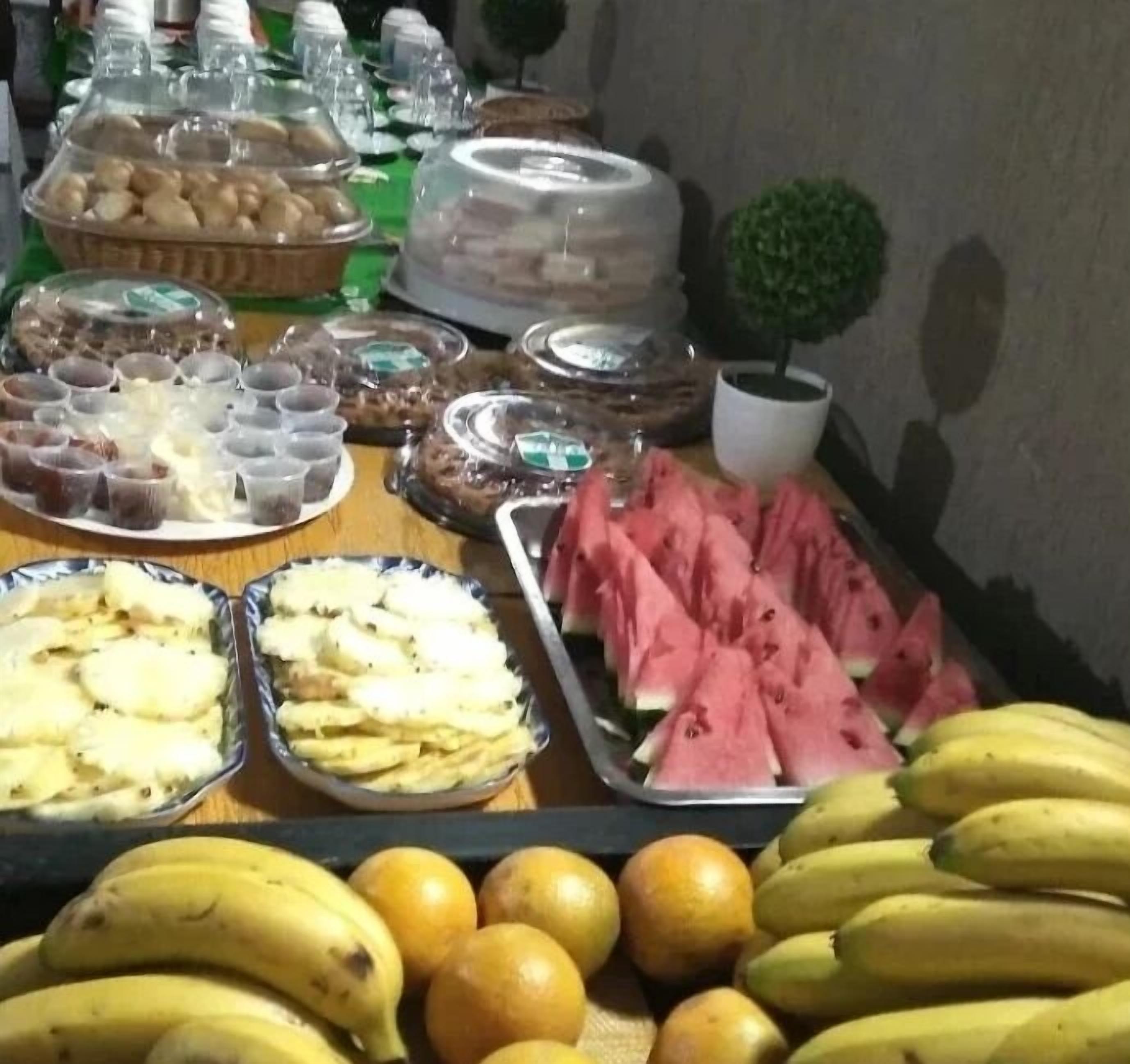 Een buffet met diverse gerechten, waaronder fruit, desserts en drankjes.