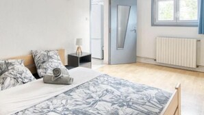 A modern bedroom with a bed, a nightstand, a door, and a window. - Apparemment à Côté du Meet (Cornebarrieu)