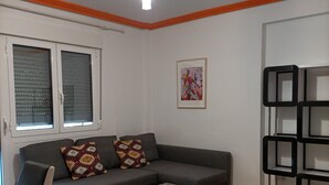 A modern living room with a grey sofa, a coffee table, and a bookshelf. - Funcional Apartamento en Iturrama (Pamplona)