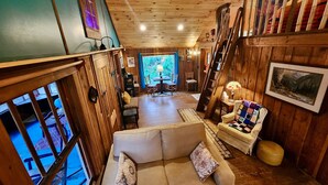 Un accogliente interno in legno con un divano, un tavolo da pranzo e una scala.