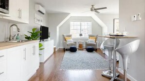 Une cuisine moderne avec des armoires blanches, un four à micro-ondes et un ventilateur de plafond.