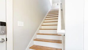 Un escalier avec des marches en bois et des murs blancs.