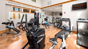 Uma academia com diversos equipamentos de ginástica, incluindo esteiras, bicicletas ergométricas e aparelhos de musculação.