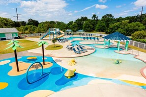 Um parque aquático com várias piscinas, toboáguas e espreguiçadeiras.