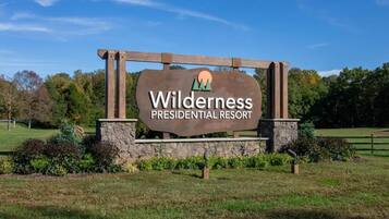 Señal para Wilderness Presidential Resort, con un logotipo de montaña y árbol.