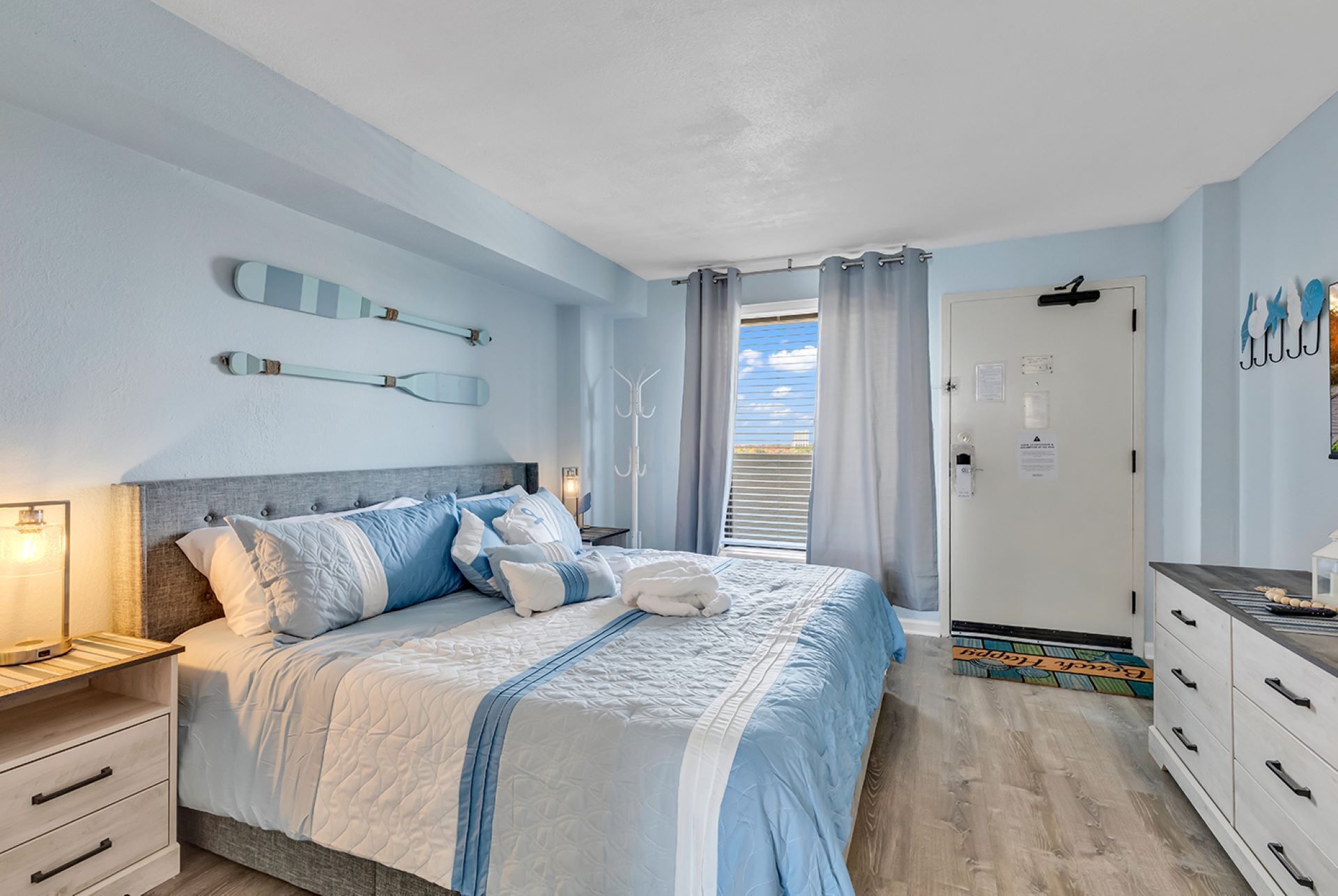 A bedroom with a bed, bedside tables, a wardrobe, and a door leading to a balcony.